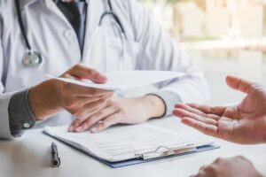 Médico em seu consultório preenchendo um atestado médico oficial em sua mesa com carimbo profissional e certificado digital.