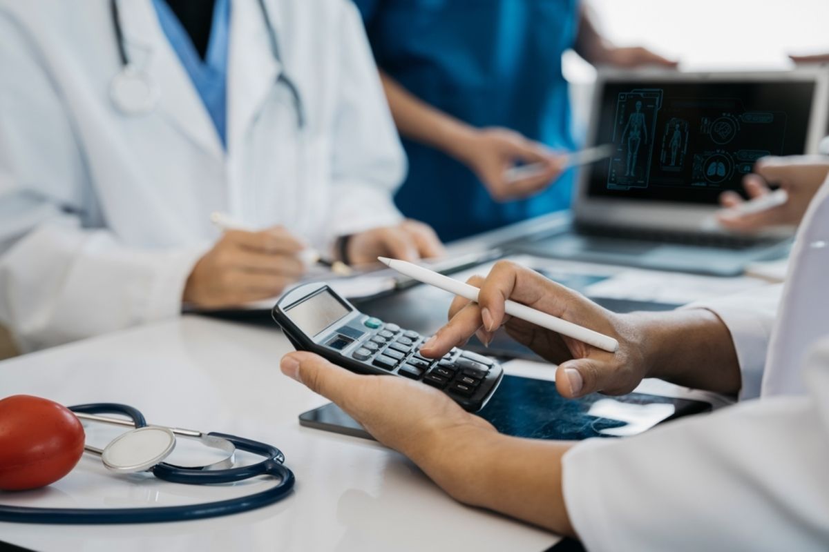 Médico em seu escritório administrativo analisando uma Nota Fiscal Eletrônica de Serviços (NFS-e) emitida com erro na tela do computador para realizar a correção digital.