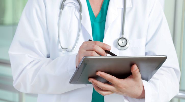 Médico e secretária organizando a segurança de dados e políticas de privacidade de pacientes na recepção do consultório.