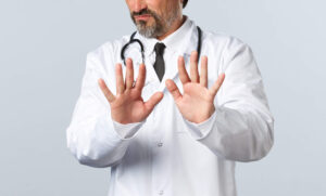 Médico em seu consultório orientando paciente sobre a transferência de cuidados médicos e encerramento ético da relação médico-paciente.