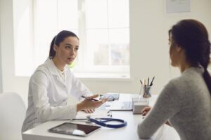 Médico em seu consultório atendendo pacientes particulares e credenciados por plano de saúde com agenda organizada.